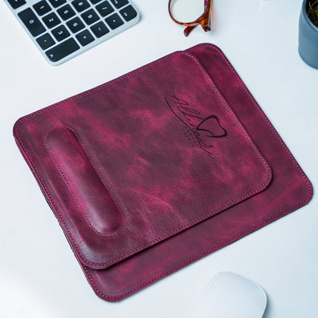 a leather mouse pad sitting on top of a desk next to a keyboard