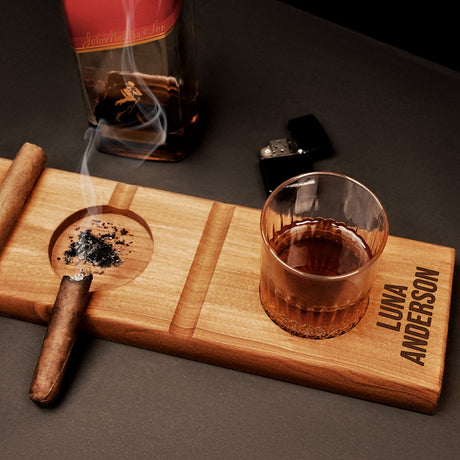 a cigar and a glass of whiskey on a wooden tray