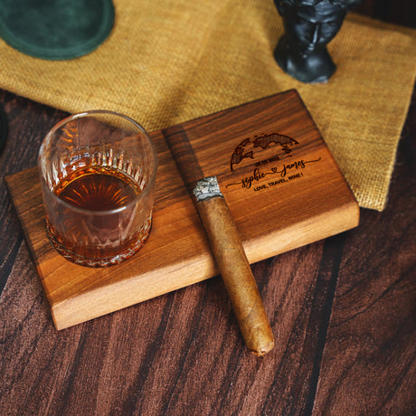 a wooden cutting board with a glass of whiskey on it