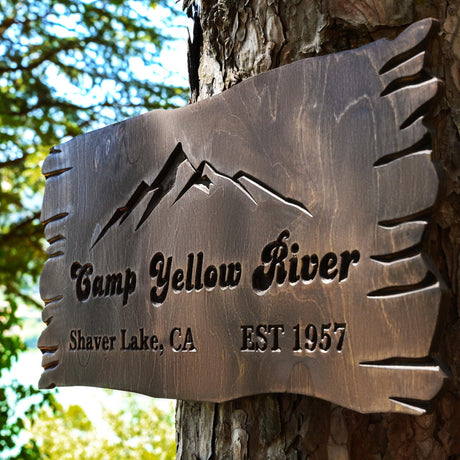 a sign on a tree that says camp yellow river