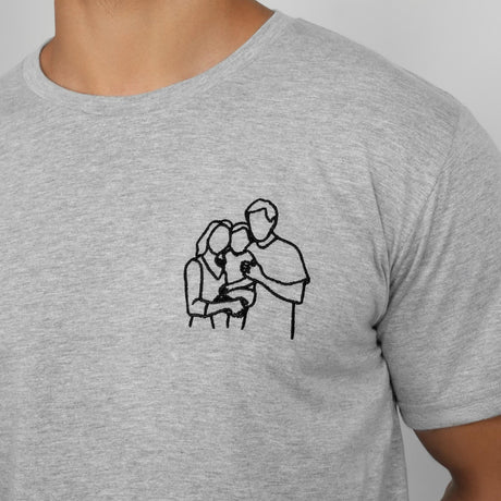 a man wearing a grey shirt with a drawing of a man holding a woman