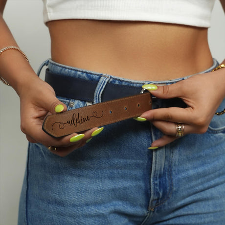 a woman is holding a belt with a name on it
