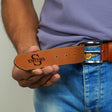 a man wearing a belt with a logo on it