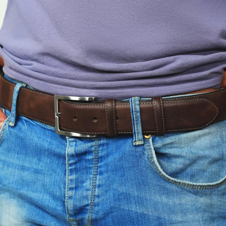 a man wearing a purple shirt and blue jeans