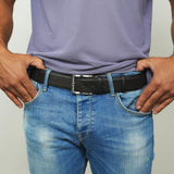 a man wearing a belt with his hands in his pockets