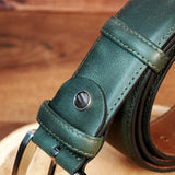 a green leather belt on a wooden surface