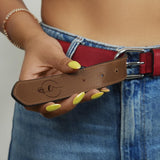 a woman is holding a belt with a smiley face on it