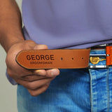 a man wearing a belt with a name tag on it