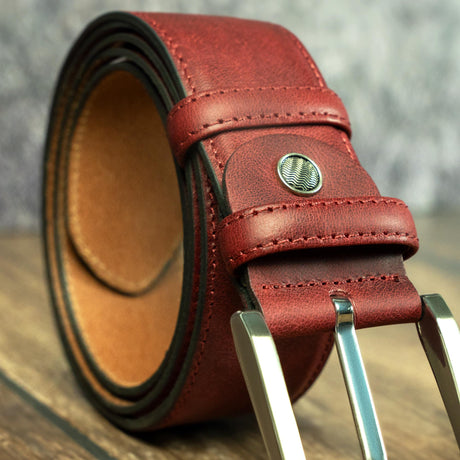 a red leather belt on a wooden table