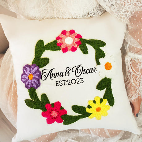 a white pillow with a floral wreath on it