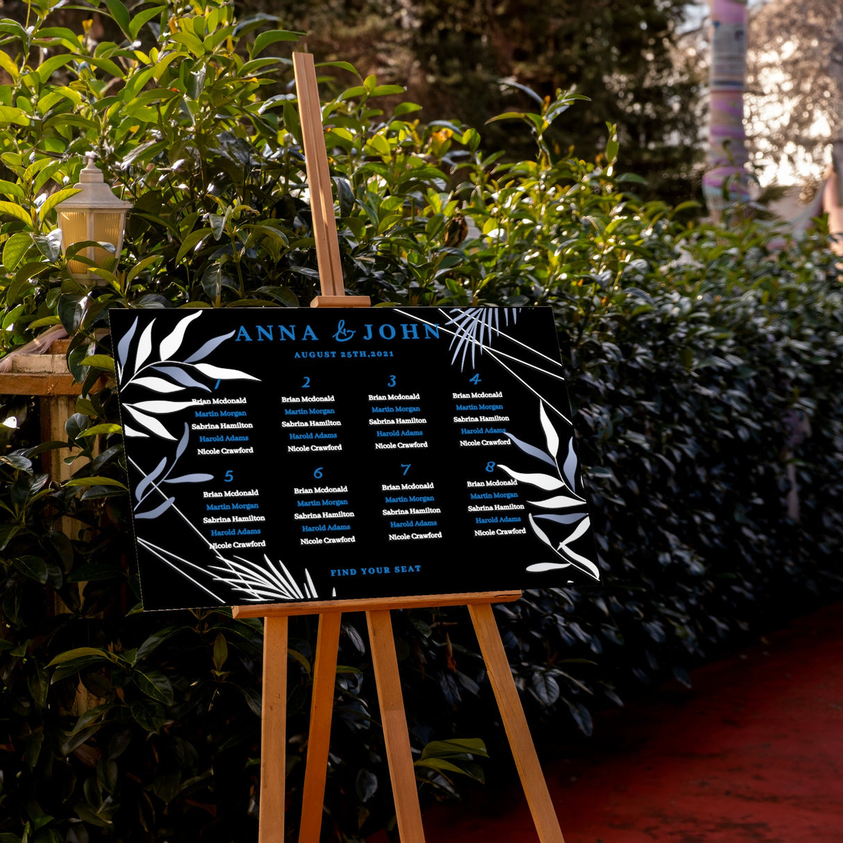 a black and white sign sitting next to a bush