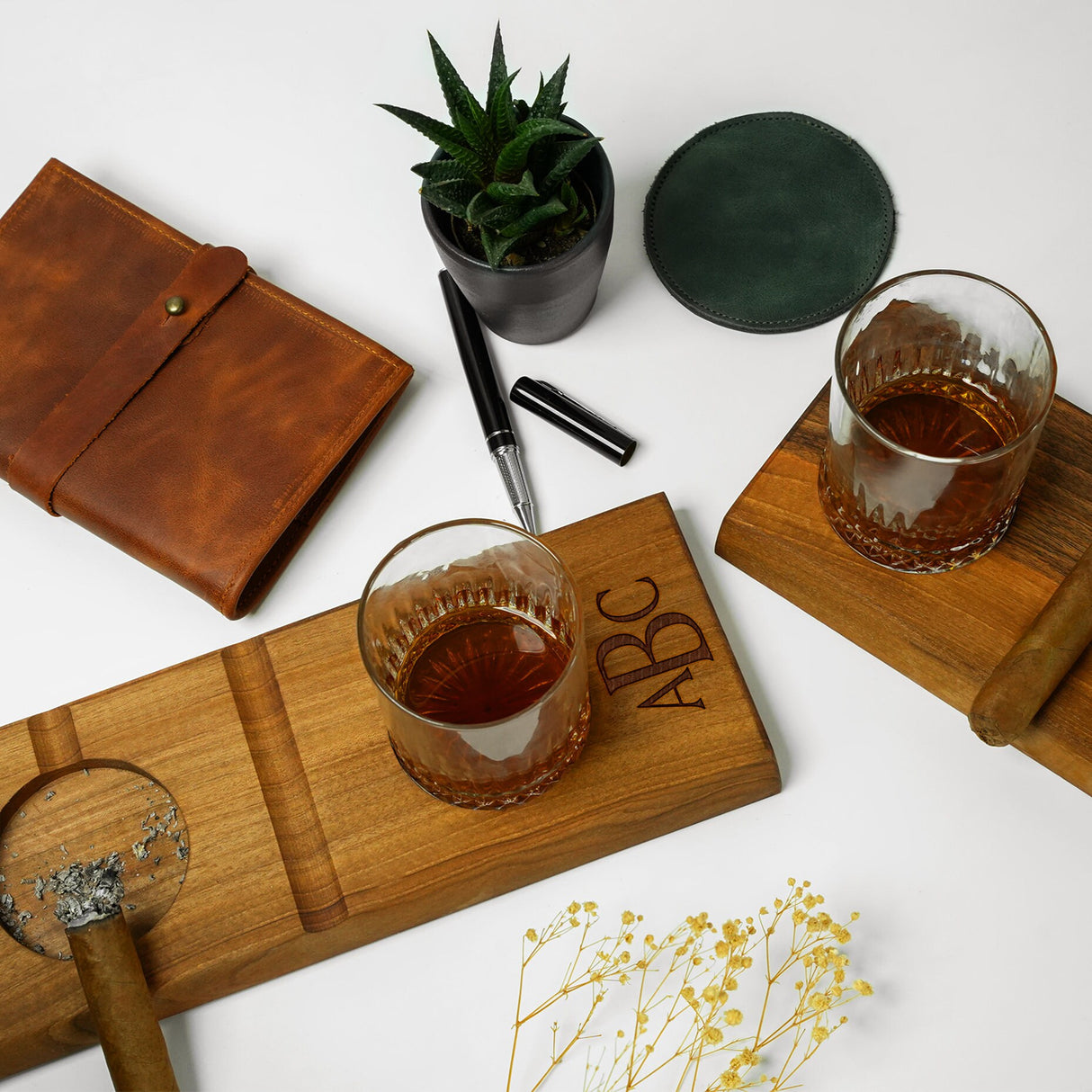 a wooden coaster with a glass and a pen on it