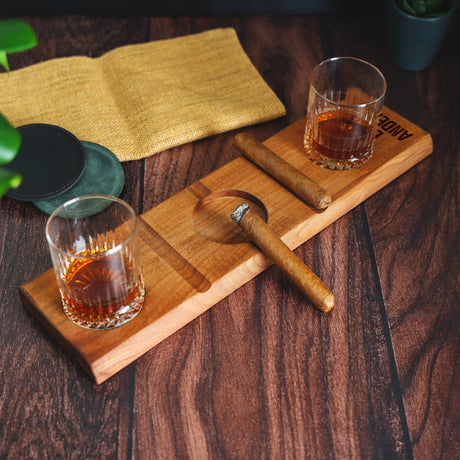 a wooden cutting board topped with two glasses of whiskey