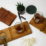 a wooden cutting board topped with a glass of whiskey