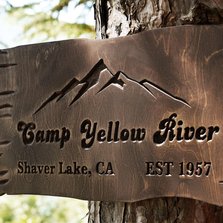 a sign on a tree that says camp yellow river