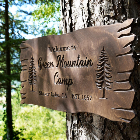 a sign on a tree that says green mountain camp