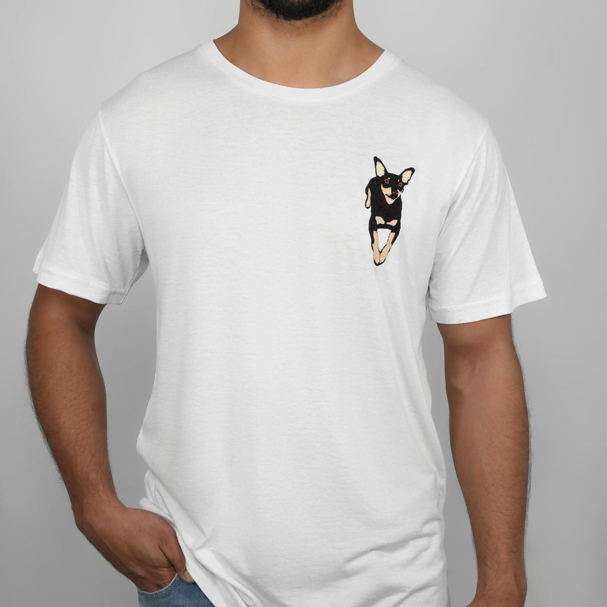 a man wearing a white t - shirt with a black and brown dog in the