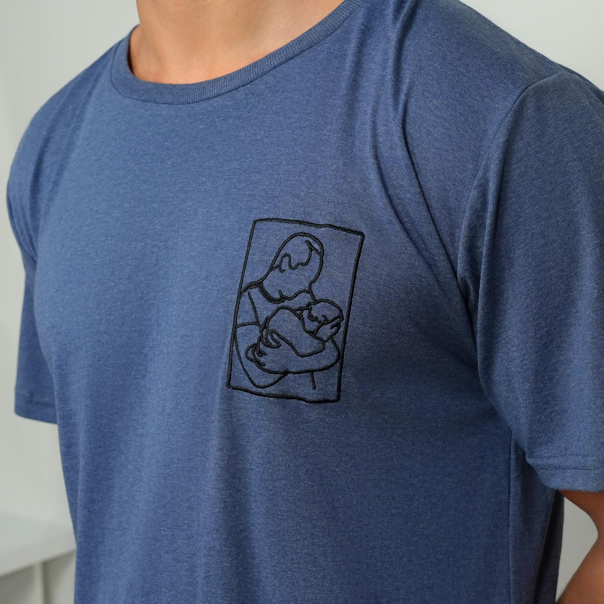 a man wearing a blue t - shirt with a picture of a person holding a