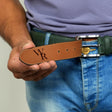 a man wearing a belt with a monogram on it