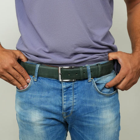 a man wearing a belt with his hands in his pockets