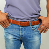 a man wearing a belt with his hands in his pockets