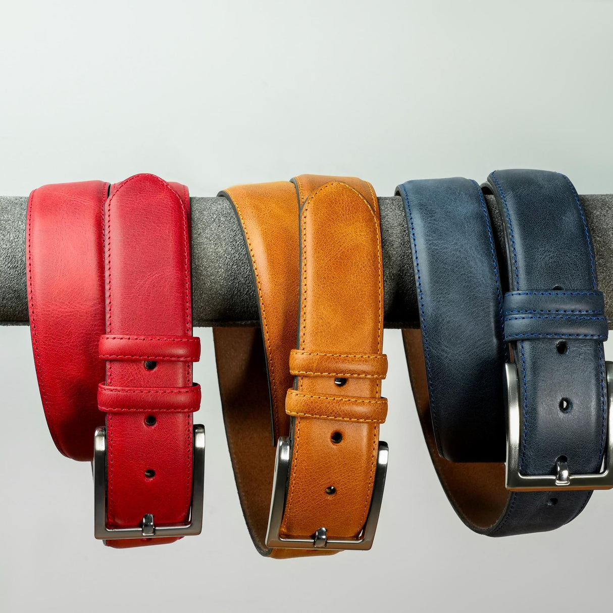 a row of different colored belts hanging on a wall