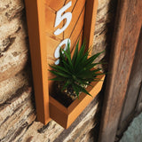 a wooden clock with a plant inside of it