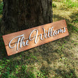 a wooden sign that says the williamss next to a tree