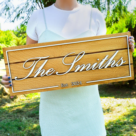 a woman holding a wooden sign that says the smiths