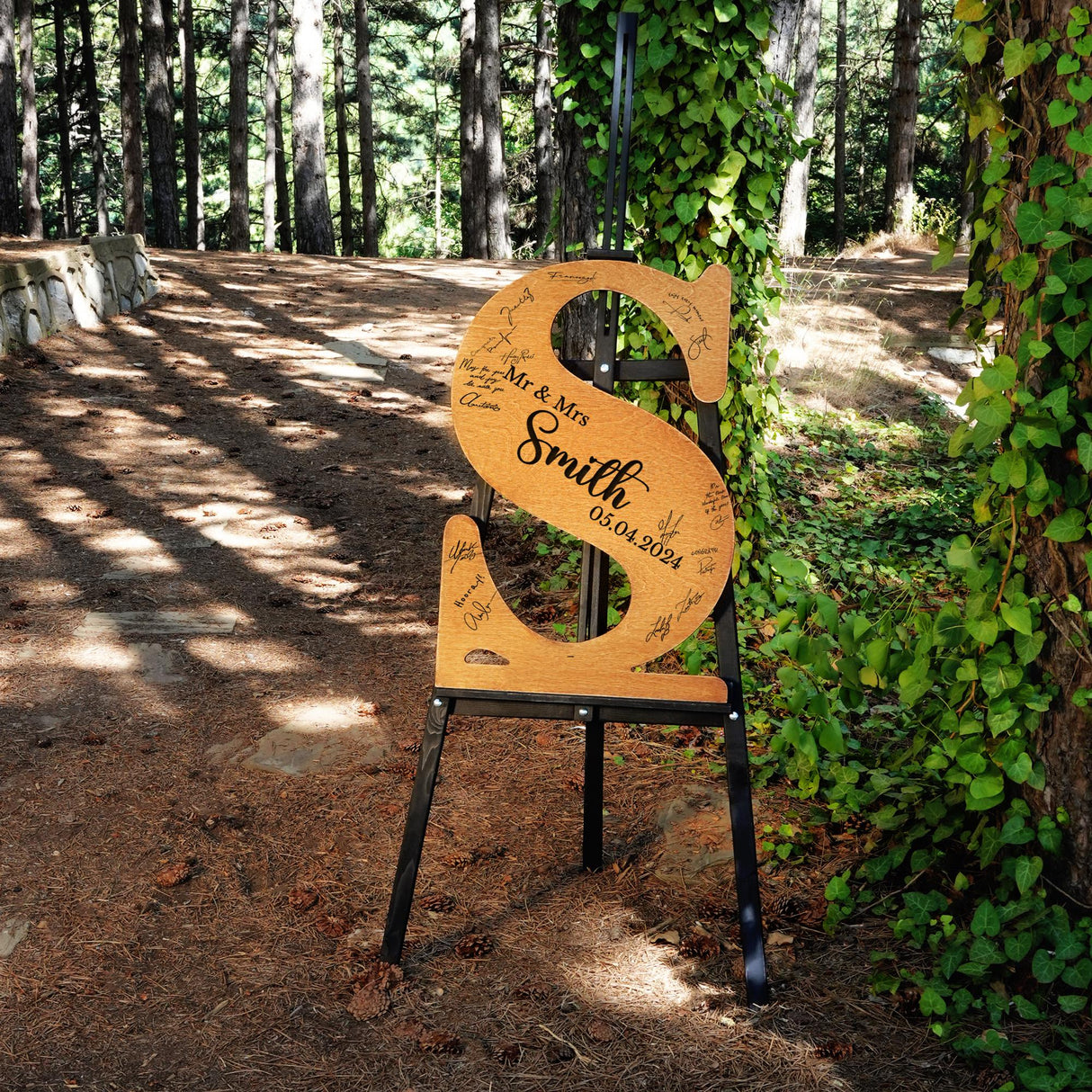 a wooden sign sitting in the middle of a forest