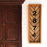 a wooden clock mounted to the side of a wall