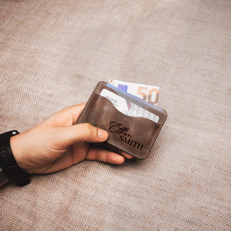 a hand holding a wallet with a 50 euro bill sticking out of it