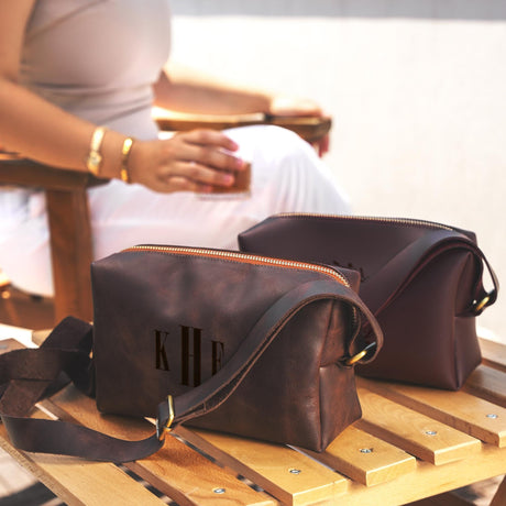 a woman sitting in a chair holding a brown purse