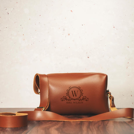 a brown leather bag sitting on top of a wooden table