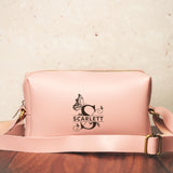 a pink purse sitting on top of a wooden table