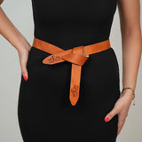 a woman in a black dress is holding a brown belt