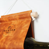 a bottle of wine sitting next to a leather bag