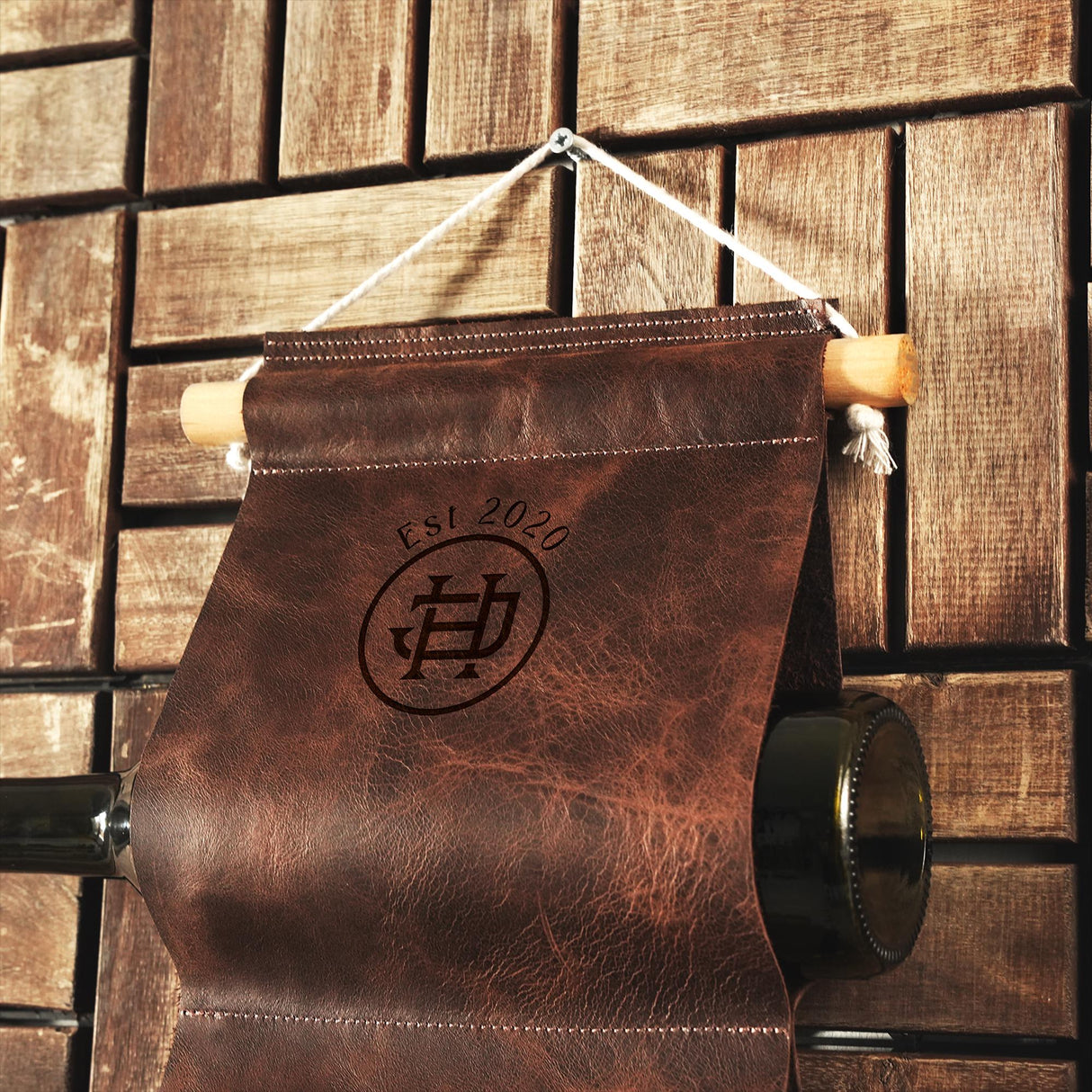 a brown leather bag hanging on a wooden wall