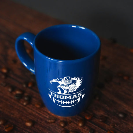 a blue coffee cup sitting on top of a wooden table