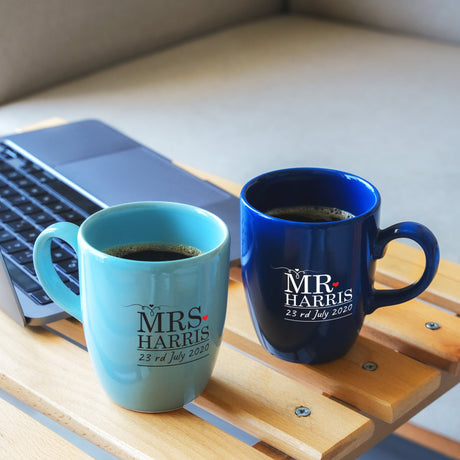 a couple of coffee cups sitting on top of a wooden table