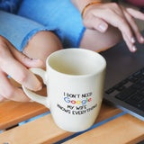 a person is typing on a laptop while holding a coffee mug