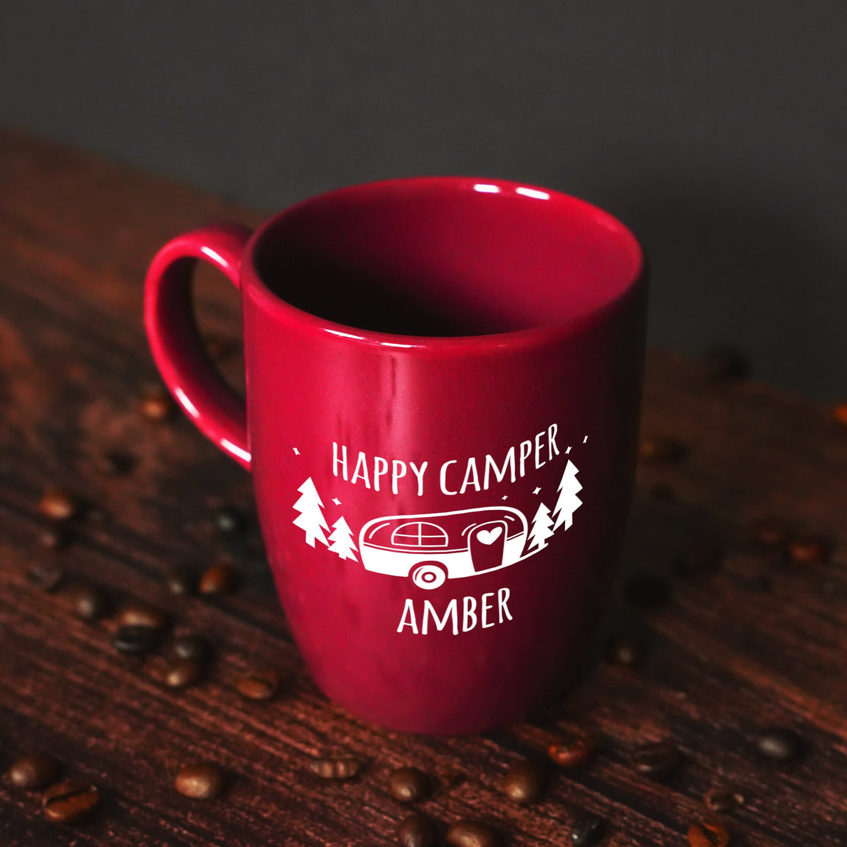 a red coffee mug sitting on top of a wooden table