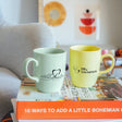 two coffee mugs sitting on top of a stack of books