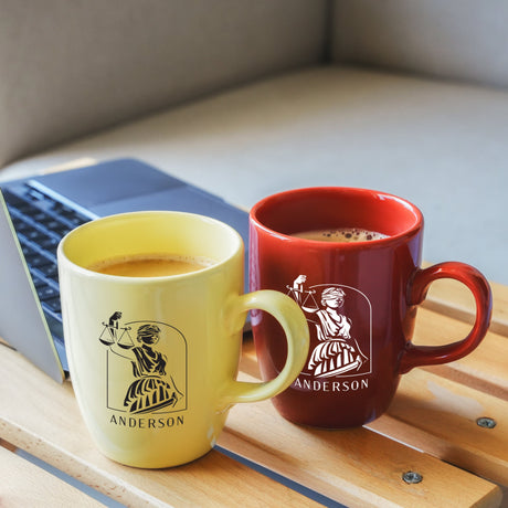 two mugs of coffee sit next to a laptop