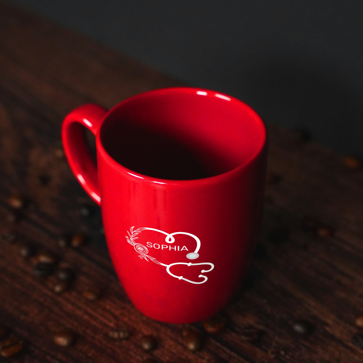 a red coffee cup sitting on top of a wooden table