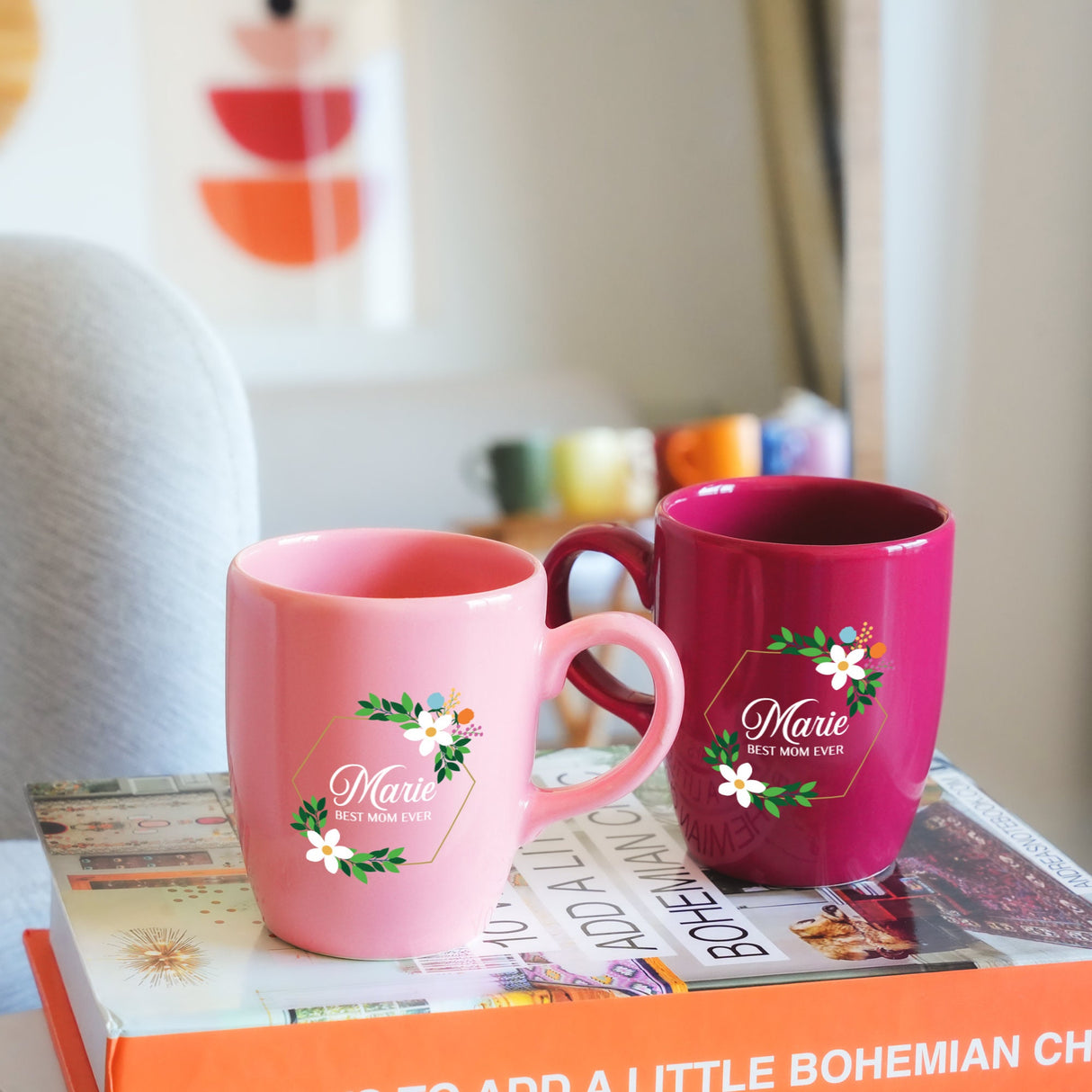 two pink coffee mugs sitting on top of a book