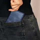 a person holding a blue wallet in their back pocket