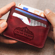 a person holding a red wallet with a credit card in it