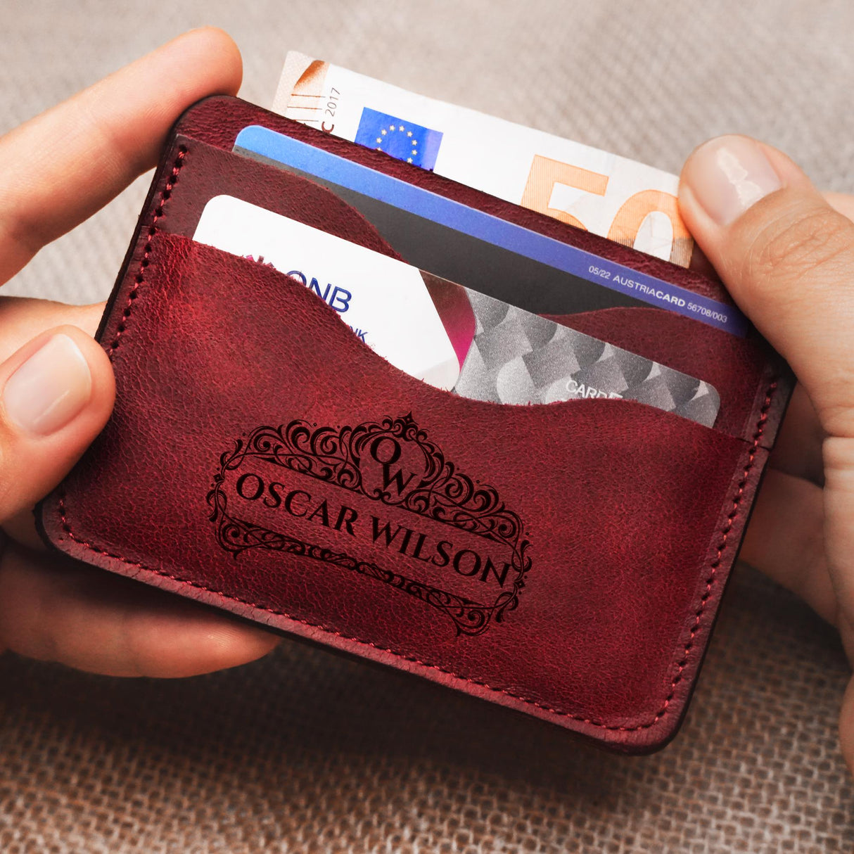 a person holding a red wallet with a credit card in it