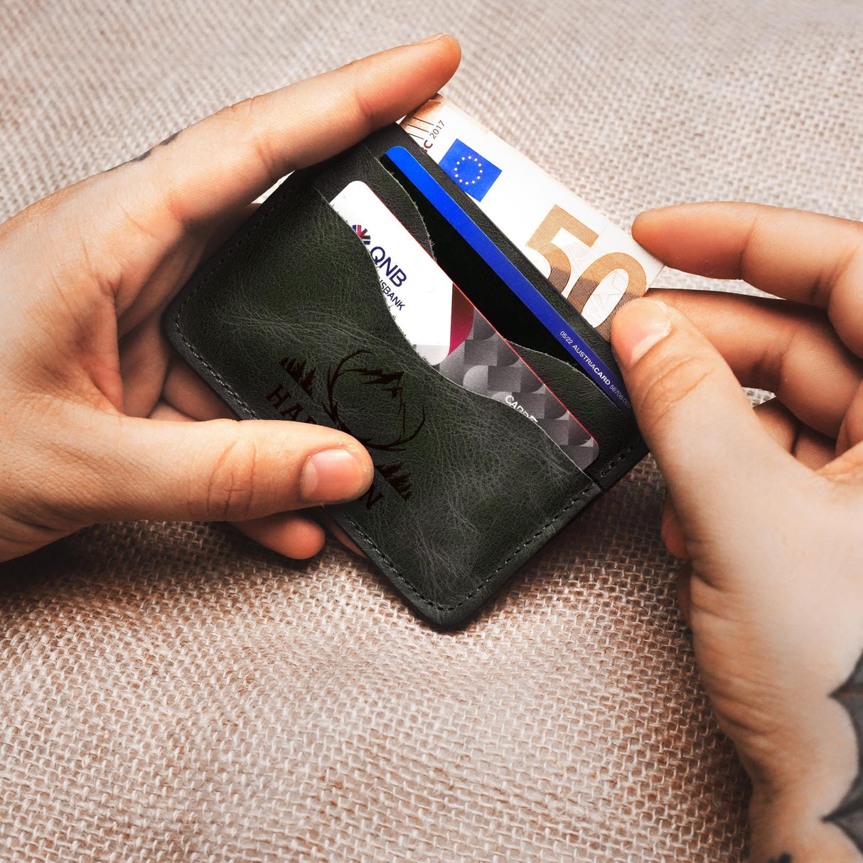 a person holding a wallet and a credit card